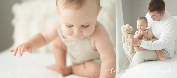 baby boy wearing cream color romper on white bed in Houston photo studio