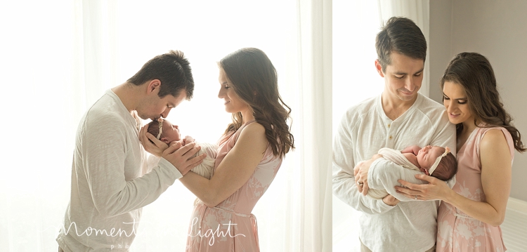 Mother and father kissing baby daughter in window of Houston newborn photography studio